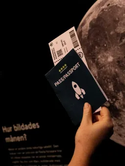 En hand som håller i ett pass och ett bordingkort.