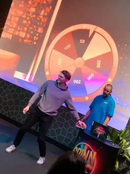 Kille står framför en publik tillsammans med en värd och trycker på en knapp.