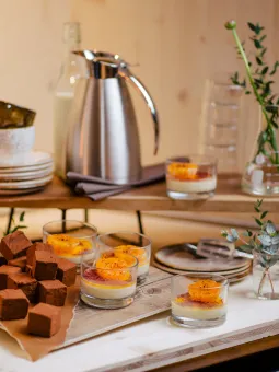 Inne i restaurangen står en bänk med fika inför ett frukostmöte. 