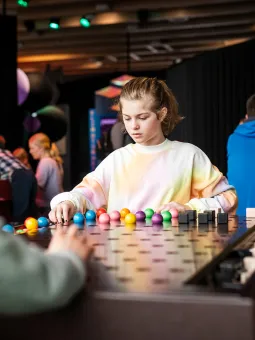 En tjej sitter och spelar Mastermind inne i utställningen Mathrix.