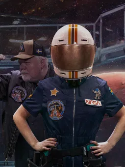 En astronaut i rymddräkt som står framför planeten Mars.