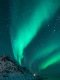 Polarsken ovanför snötäckta berg.