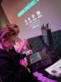 Två tjejer trycker på ett upplyst på ett tangentbord.