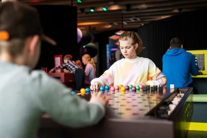En tjej sitter och spelar Mastermind inne i utställningen Mathrix.