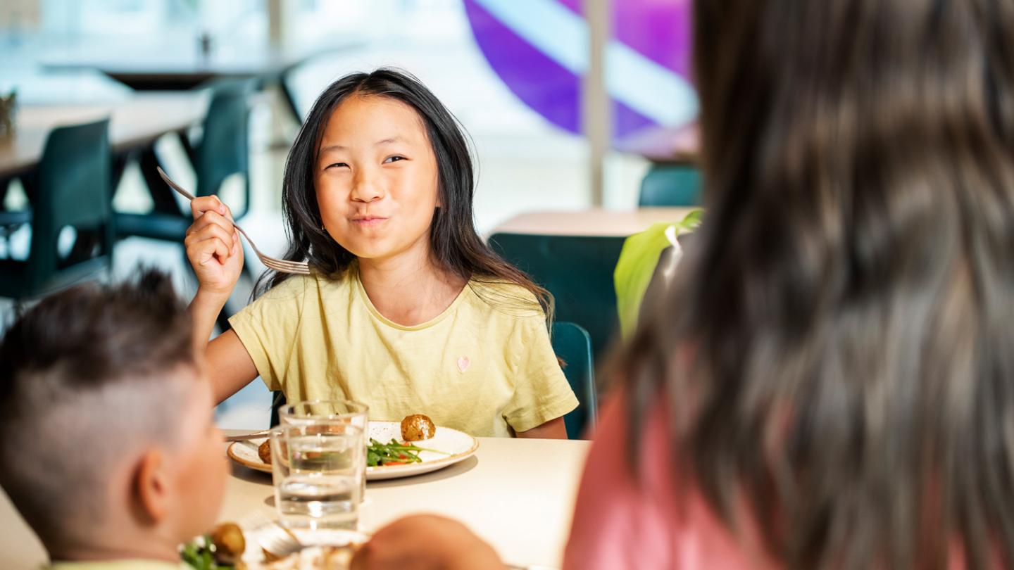 En barnfamilj sitter och äter lunch inne i Universeums fina restaurang.